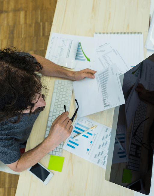 male graphic designer looking graph document 1
